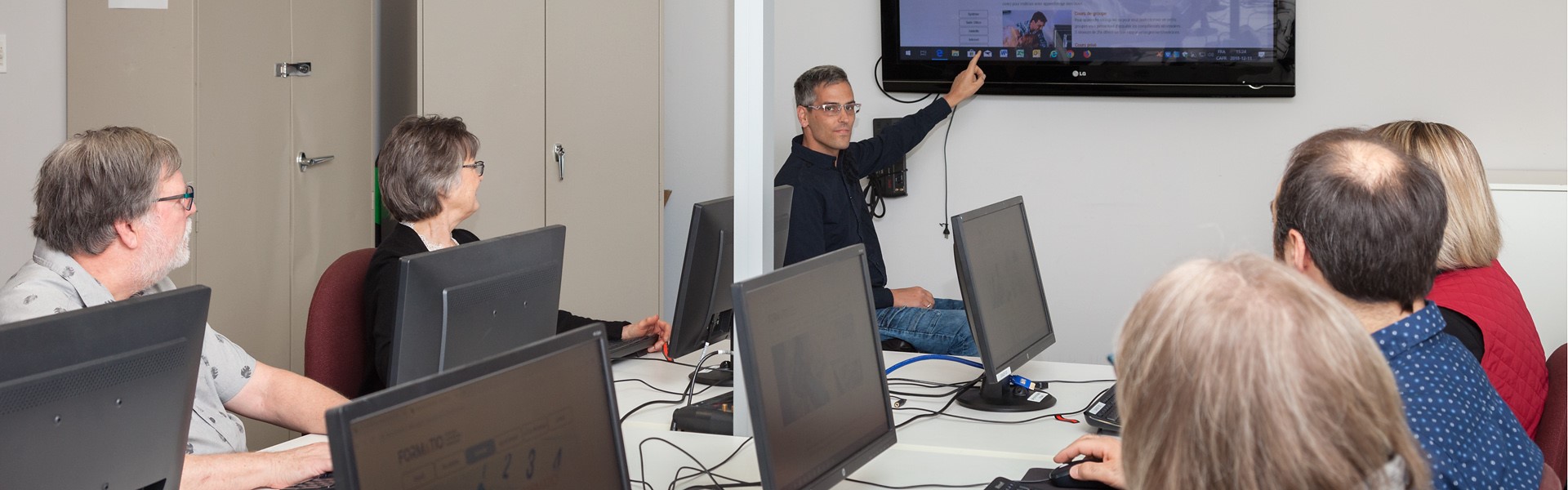 Maxime Jacottin dans une salle de formation, au tableau, donnant un cours d'informatique